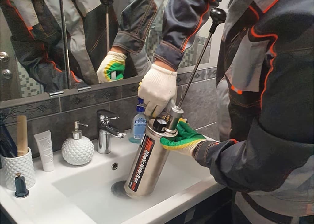 Специалист с пневматическим оборудованием для прочистки канализации