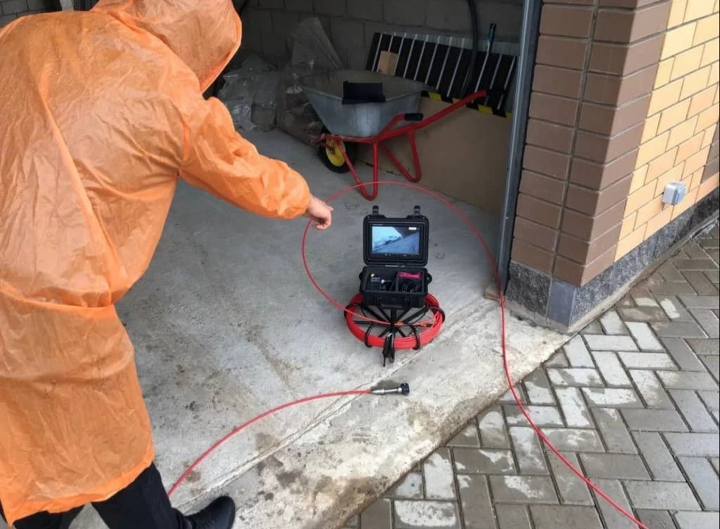 Мастер в защитном костюме проводит диагностику на объекте